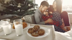 Family enjoying Christmas morning with cookies and milk by the tree.